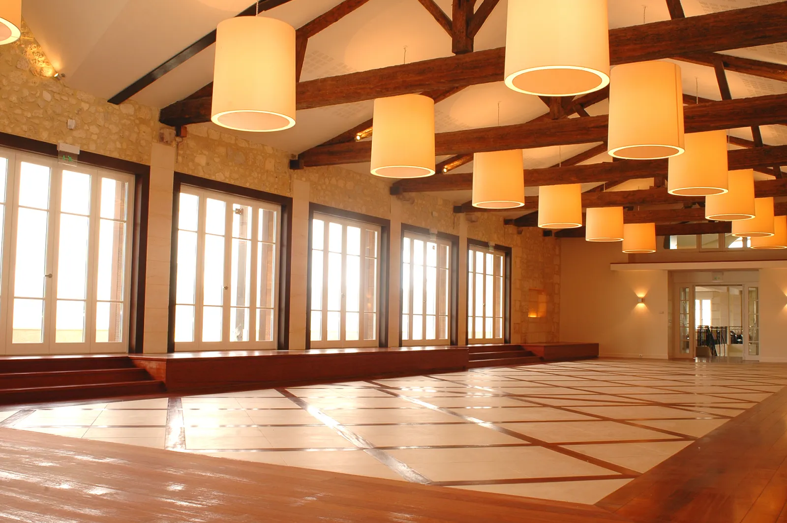 Modern interior space with wooden beams, pendant lights, and large windows in a contemporary architectural setting