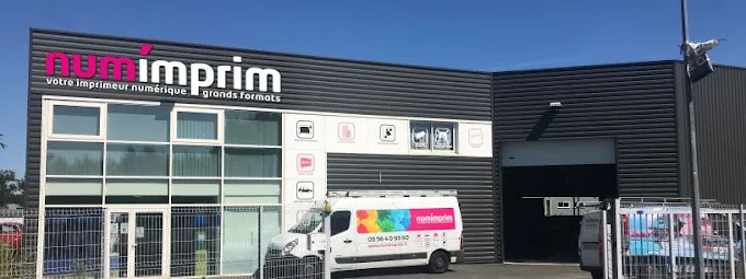 NumImprim printing shop storefront in Bordeaux with display windows, signage, and branded delivery van parked outside