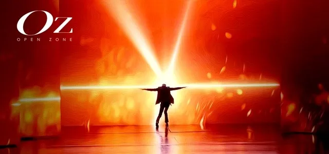 Silhouette of a person standing with arms outstretched against a bright golden-orange light source, with 'OZ OPEN ZONE' branding visible in the upper left corner