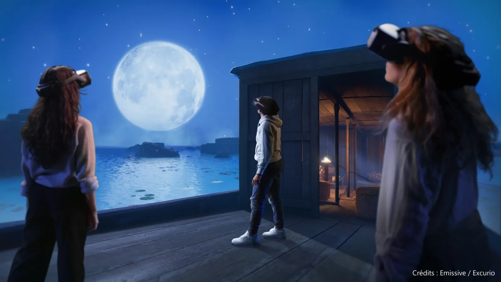 Three people wearing VR headsets stand on a wooden platform at night, gazing at a large glowing moon over a moonlit ocean landscape with a dark building structure, in a virtual reality experience.