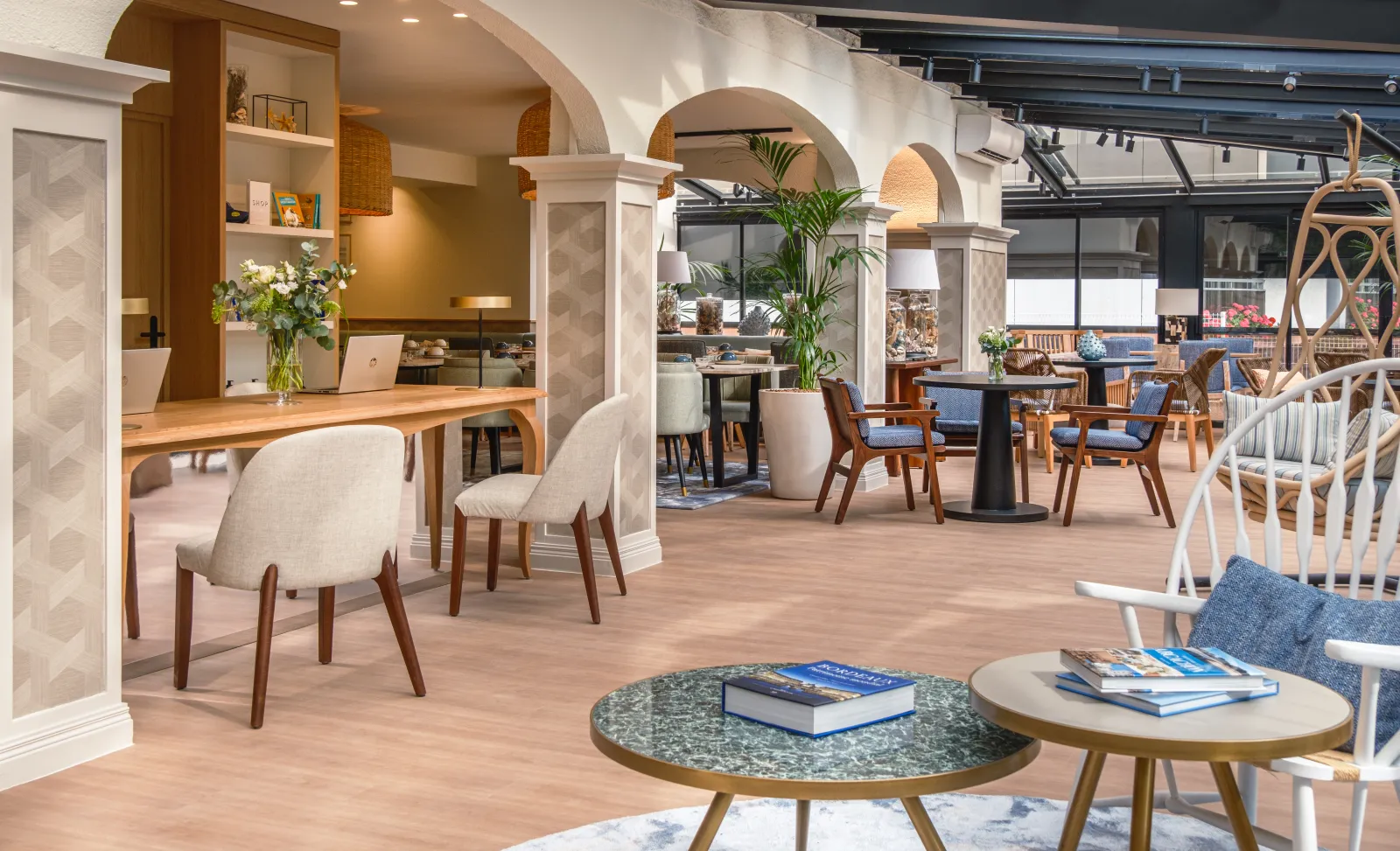 Modern hotel lobby and lounge area at Arcanse by Inwood in Bordeaux, featuring contemporary furniture, decorative arches, natural wood elements, green plants, and ambient lighting