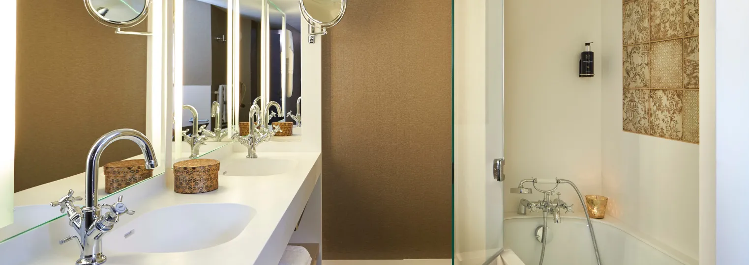 Modern bathroom with double vanity sinks, illuminated mirrors, brown and cream tiled walls, glass shower enclosure, and chrome fixtures at Best Western Premier Hôtel Bayonne Etche Ona in Bordeaux.
