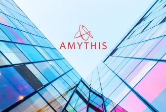 Modern glass building facade with blue and pink tones, featuring the red Amythis logo and atom symbol centered against a light sky background