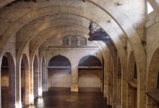 Interior of a brick warehouse with barrel-vaulted ceilings, multiple arches, and large doors, part of the CAPC Museum of Contemporary Art in Bordeaux