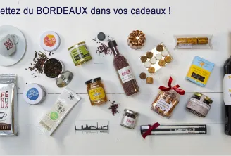 Bordeaux gift collection featuring coffee, wine, tea, chocolates, pastries, and local specialty products arranged on a white surface with the text 'Put Bordeaux in your gifts'