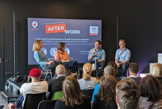 Panel discussion at La French Tech Bordeaux AfterWork event on April 9th, featuring four speakers seated on stage discussing leadership and human aspects of business, with an audience seated in front viewing the presentation.
