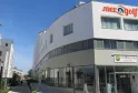 Modern white curved apartment-hotel building with 'Mer & Golf City' signage, featuring large windows and a ground floor reception area in an urban residential district.