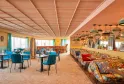 Modern hotel restaurant and lounge area with colorful banquette seating, blue chairs, geometric ceiling design, pendant lighting, and large windows overlooking Bordeaux
